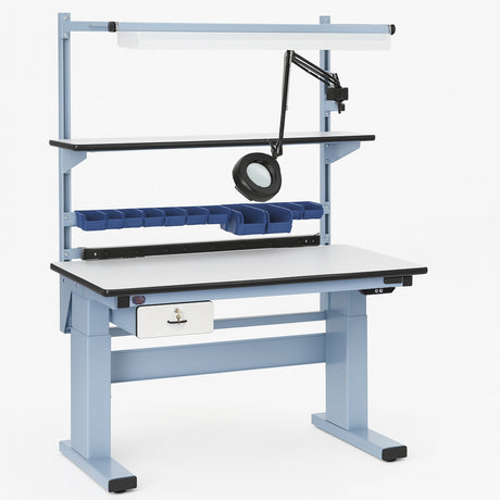 Ergonomic adjustable industrial workbench with light blue steel frame, white laminate surface, overhead LED light, and attached magnifying lamp