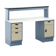Heavy-duty industrial workbench with a white laminate top, dual pedestal base in blue, and beige locking drawer units. Features a raised upper shelf with a black edge for additional storage. Designed for manufacturing, assembly, or technical work environments