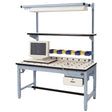 Rotating-top industrial workstation with a white perforated surface, mounted CRT monitor, multiple small parts bins in yellow and blue, overhead lighting, upper utility shelf, and integrated power strip on a light blue steel frame.